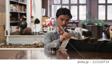 Front view of handsome biracial man with short dark hair enjoying time at home, sitting with his fee Front view of handsome biracial man with short dark hair enjoying time at home, sitting with his fee 121320714