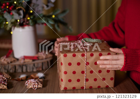 female hands holding Christmas gift box at home, New Year's Eve 121323129