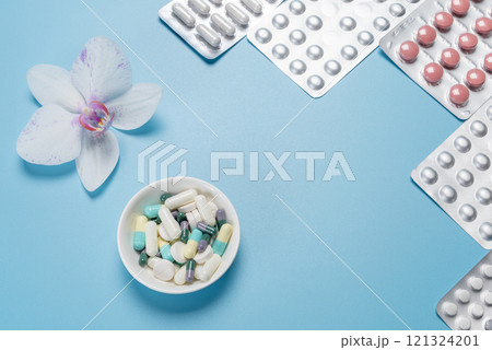Bowl with different capsules and medicine blister packs with pills. 121324201