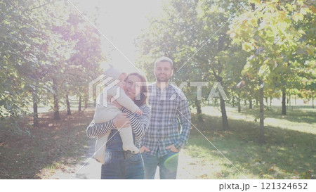 A joyful family moment outdoors in a beautiful sunlit park, celebrating love and genuine connection together A joyful family moment outdoors in a beautiful sunlit park, celebrating love and genuine connection together 121324652