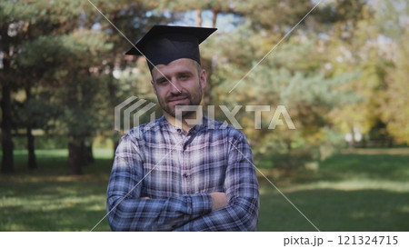A proud graduate outdoors captures the moment, showcasing their academic achievement and a promising future A proud graduate outdoors captures the moment, showcasing their academic achievement and a promising future 121324715