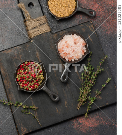Himalayan salt, peppercorns and mustard seeds on kitchen table, top view Himalayan salt, peppercorns and mustard seeds on kitchen table, top view 121325305