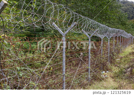 Border area between Iran and Azerbaijan featuring barbed wire fencing and natural surroundings 121325619
