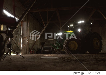 John Deere modern tractor parked in the barn ready to drive outside for the field. 06 april 2017 Wroclaw, Poland. John Deere modern tractor parked in the barn ready to drive outside for the field. 06 april 2017 Wroclaw, Poland. 121325938