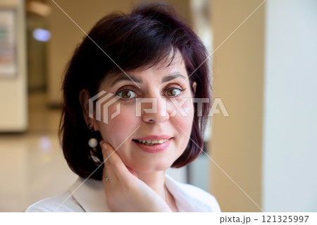 Portrait of a middle aged woman with white earrings Portrait of a middle aged woman with white earrings 121325997