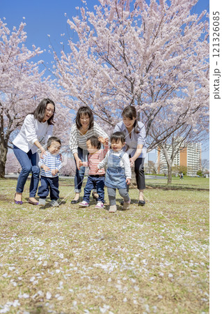 桜の咲く公園で遊ぶ母と子たち 121326085