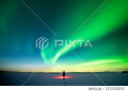 Man with red flashlight standing on snowy field 121326281
