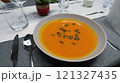 Creamy orange pumpkin soup with seeds served on a table. 121327435