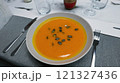 Creamy orange pumpkin soup with seeds served on a table. 121327436