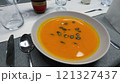 Creamy orange pumpkin soup with seeds served on a table. 121327437