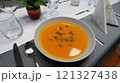 Creamy orange pumpkin soup with seeds served on a table. 121327438