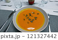 Creamy orange pumpkin soup with seeds served on a table. 121327442