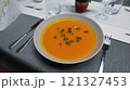 Creamy orange pumpkin soup with seeds served on a table. 121327453