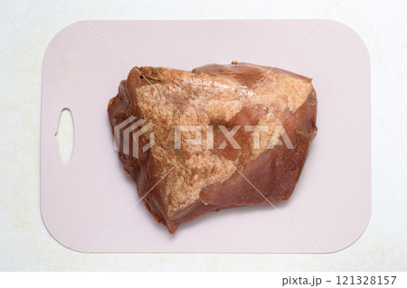 Top view of a piece of marinated meat on a plastic cutting board. Top view of a piece of marinated meat on a plastic cutting board. 121328157