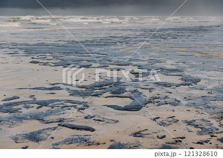 The ocean and the beach are polluted with oil. Beach oil spill impact, pollution, waste disposal. The ocean and the beach are polluted with oil. Beach oil spill impact, pollution, waste disposal. 121328610