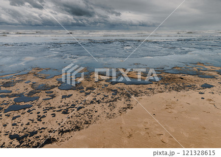 Oil leaked in coastline after a tanker wreck. Oil fuel polluted and destroy beach Oil leaked in coastline after a tanker wreck. Oil fuel polluted and destroy beach 121328615