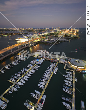 Expensive yachts and motorboats docked in Biscayne Bay harbor in downtown district of Miami, Florida. Marina bay with luxury sailboats Expensive yachts and motorboats docked in Biscayne Bay harbor in downtown district of Miami, Florida. Marina bay with luxury sailboats 121330346