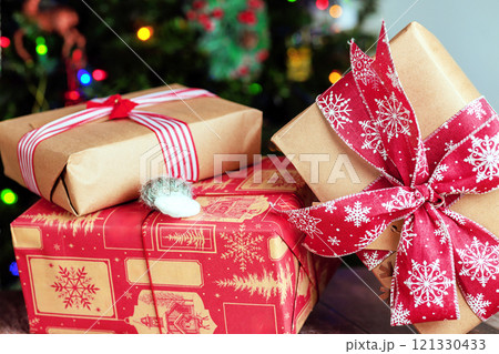 Beautifully wrapped gifts await opening beneath sparkling Christmas tree, filled with joy, holiday spirit. 121330433