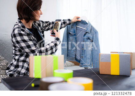 Young Woman Takes Photos Of A Pre-Owned Jeans Jacket To Sell Online And Focuses On Selling Old Clothes Young Woman Takes Photos Of A Pre-Owned Jeans Jacket To Sell Online And Focuses On Selling Old Clothes 121332478