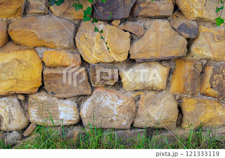 The masonry of the wall is made of natural layered stones, between which there are joints of different sizes made of mortar. Background of building materials The masonry of the wall is made of natural layered stones, between which there are joints of different sizes made of mortar. Background of building materials 121333119