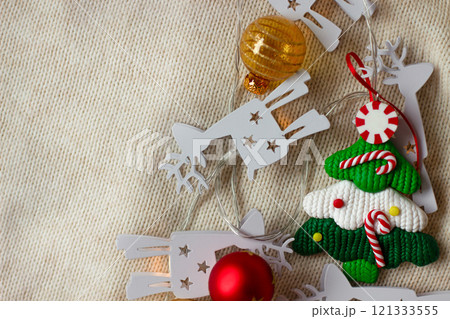 Christmas decorations, a toy Christmas tree on a beige knitted background 121333555