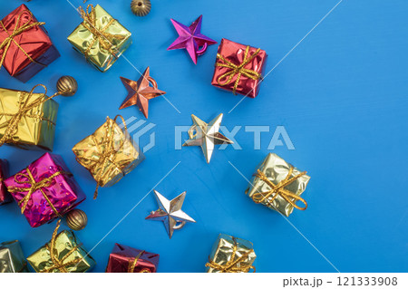 Colorful gift boxes and stars with gold decorations on a blue background Colorful gift boxes and stars with gold decorations on a blue background 121333908