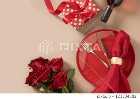 Valentine's day. Romantic dinner for date with red plate, chocolate sweets, romantic gift, wine and red roses on beige background. View from above. Copy space. 121334382