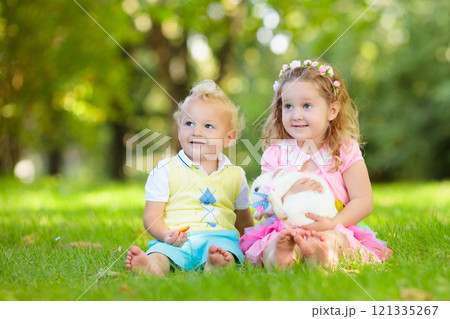 Kids playing with pet rabbit 121335267