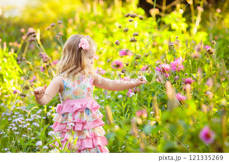 Little girl in flower garden Little girl in flower garden 121335269