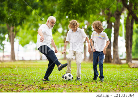 Grandfather and kids play football in summer park Grandfather and kids play football in summer park 121335364