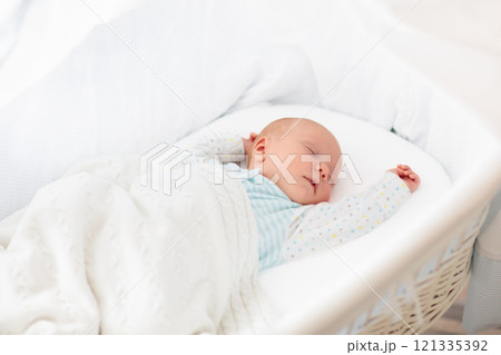 Cute newborn baby in white bed Cute newborn baby in white bed 121335392