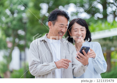 スマホを使う笑顔の中年夫婦 スマホを使う笑顔の中年夫婦 121335479