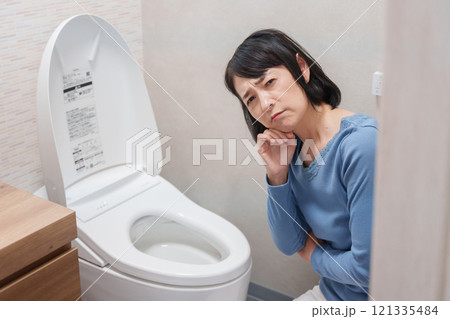トイレのトラブルに悩むミドル女性 121335484