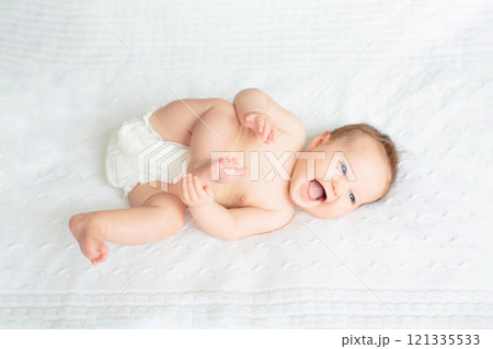 Little baby on white bed 121335533