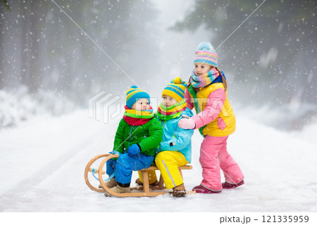 Kids play in snow in winter park 121335959