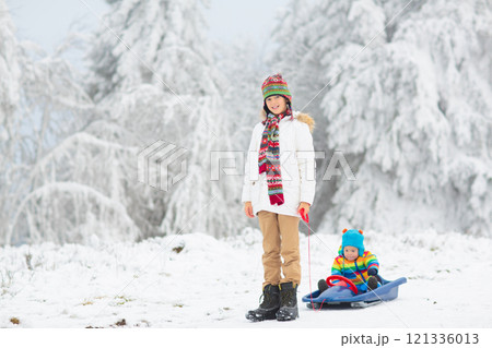 Kids play in snow in winter park 121336013
