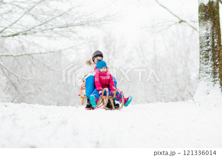 Kids play in snow in winter park 121336014