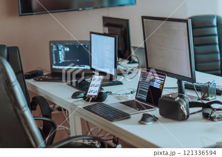 Computer screens running programming code in empty software developing agency office and computers parsing data algorithms in background. Neural network servers cloud computing in data room. 121336594