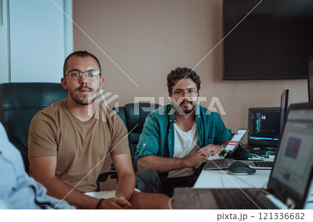 Programmers engrossed in deep collaboration, diligently working together to solve complex problems and develop innovative mobile applications with seamless functionality. 121336682
