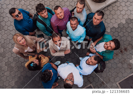 A top view photo of group of businessmen and colleagues standing together, looking towards the camera, symbolizing unity and teamwork. 121336685