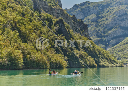 A group of friends enjoying having fun and kayaking while exploring the calm river, surrounding forest and large natural river canyons 121337165