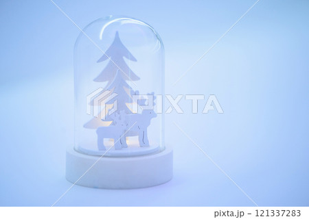 Christmas composition with white Christmas trees and two wooden deer inside a glass cap. Christmas composition with white Christmas trees and two wooden deer inside a glass cap. 121337283