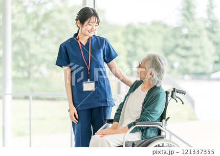 介護施設・病院で働く看護師・介護福祉士・理学療法士・作業療法士・言語聴覚士と高齢者・シニア女性 121337355