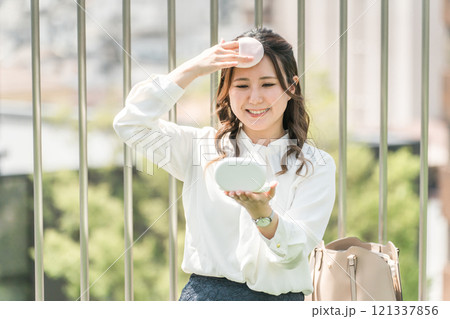 おでこの化粧直し・メイク直しをする女性（皮脂・Tゾーン） 121337856