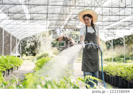 Young Woman Engaged in Sustainable Farming Practices Inside a Modern Greenhouse Environment Young Woman Engaged in Sustainable Farming Practices Inside a Modern Greenhouse Environment 121338094
