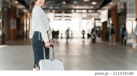 駅でスーツケースを持った出張・旅行帰りの女性・ビジネスウーマン 駅でスーツケースを持った出張・旅行帰りの女性・ビジネスウーマン 121338186
