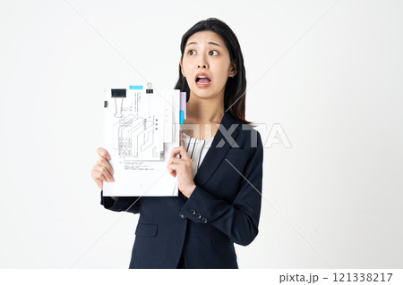 経費精算の紙を持って悩む経理部の女性 経費精算の紙を持って悩む経理部の女性 121338217