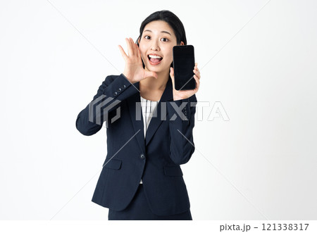 スマホを持って叫ぶスーツ姿の若い女性 121338317
