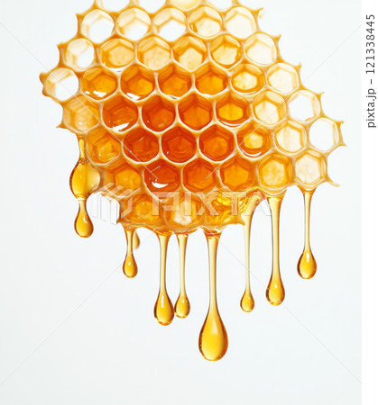 Golden honeycomb dripping with fresh honey against white background, showcasing natural beauty and texture of honeycomb structure 121338445