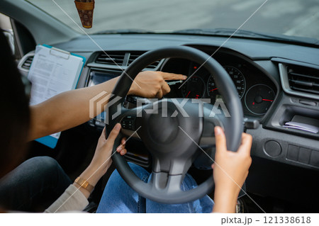 An instructor guides a student driver on the importance of dashboard controls An instructor guides a student driver on the importance of dashboard controls 121338618